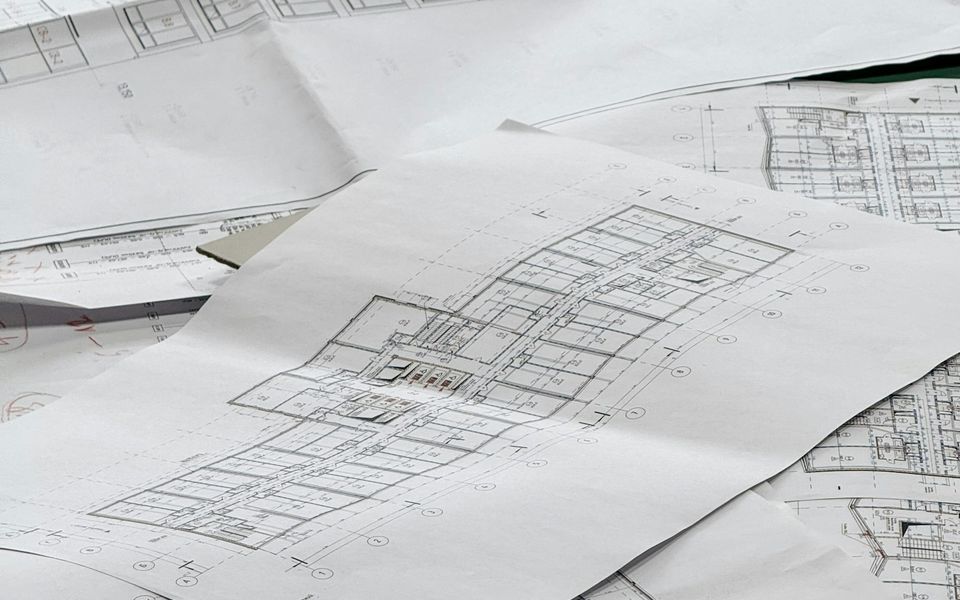 Peças desenhadas de um projeto de arquitetura sobre uma mesa