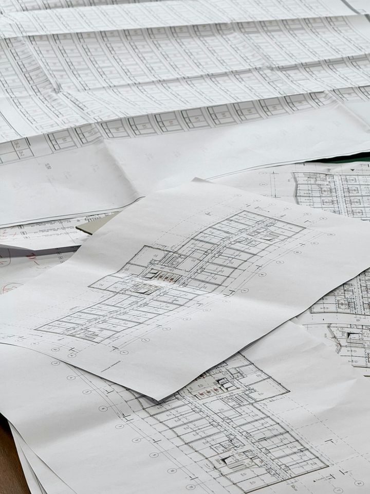 Peças desenhadas de um projeto de arquitetura sobre uma mesa